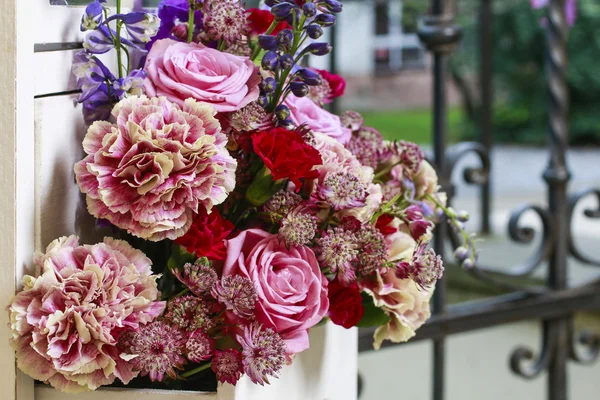 Blumenschmuck mit rosa Rosen, Nelken und Delphinblüten — Stockfoto