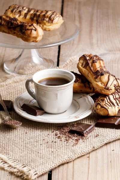 Xícara de café e eclairs — Fotografia de Stock