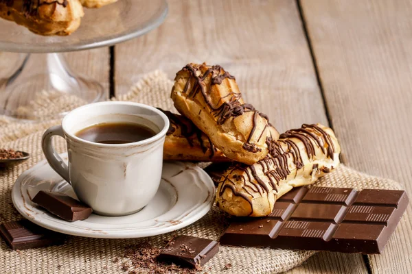Cup of coffee and eclairs — Stock Photo, Image