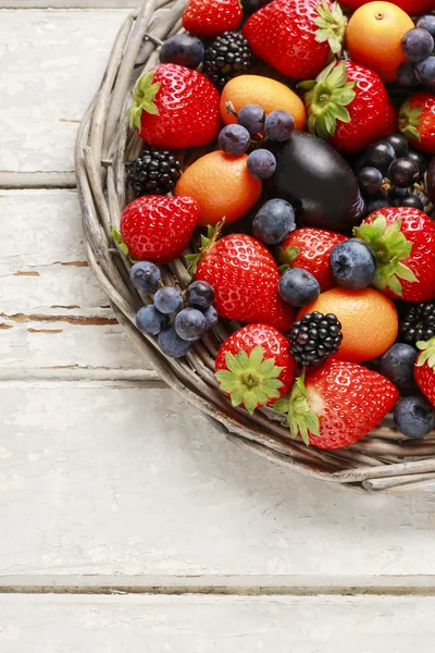 Mandje met fruit: aardbeien, bosbessen, bramen, druiven — Stockfoto