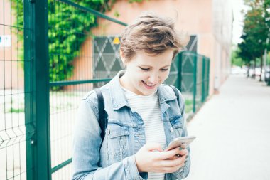 Sokakta akıllı telefon ile mutlu gülen kadın