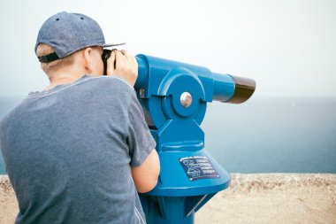 Panoramik teleskopla bakarak genç 