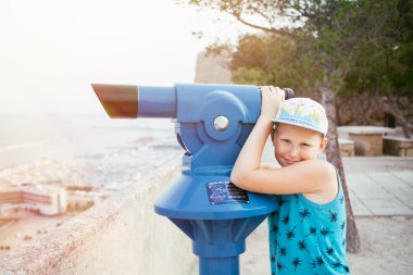 Genç çocuk konumlar görmek için panoramik teleskopla bakmak istiyor
