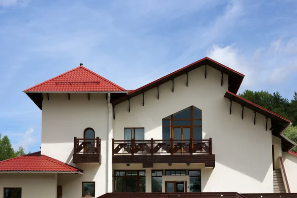 Cottage com telhado de telha de metal vermelho — Fotografia de Stock
