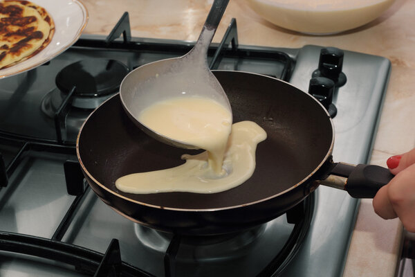 Pouring the dough into the hot pan by ladle