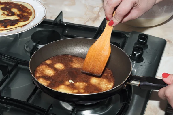 Pancake is frying in the pan at the gas-stove — Stock Photo, Image