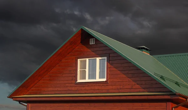 Gröna plåttak under mörka molnig himmel — Stockfoto