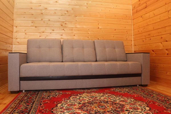 Interno della casa in legno - divano e moquette — Foto Stock