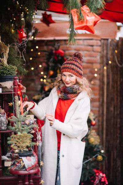 白いスーツの女性面白いです装飾された輝きのライト家の近くに輝くクリスマスツリー滞在 — ストック写真