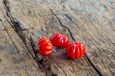 Tropical fruit called Pitanga, Brazilian cherry,Suriname cherry,Cayenne cherry on a woodem backgraund.Shallow depth of field. clipart