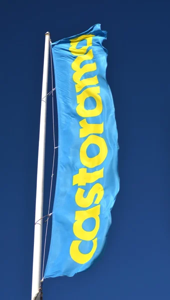 Señal de Castorama ondeando bandera contra el cielo azul — Foto de Stock