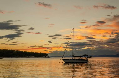 Hırvatistan 'ın Brac adasındaki Splitska' daki Adriyatik körfezi üzerinde gün batımında karamsar bulutlar