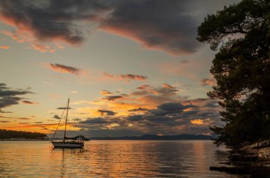 Hırvatistan 'ın Brac adasındaki Splitska' daki Adriyatik körfezi üzerinde gün batımında karamsar bulutlar