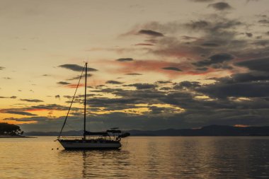 Hırvatistan 'ın Brac adasındaki Splitska' daki Adriyatik körfezi üzerinde gün batımında karamsar bulutlar
