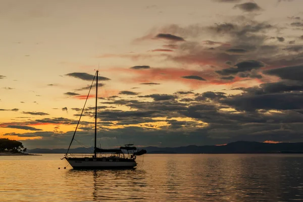 Hırvatistan 'ın Brac adasındaki Splitska' daki Adriyatik körfezi üzerinde gün batımında karamsar bulutlar