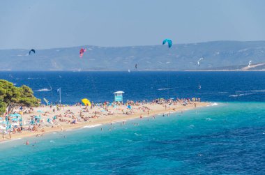 Golden Cape plajında bir sürü insan var. Altın Pelerin, Hırvatistan 'ın Brac adasındaki en ünlü plajı..