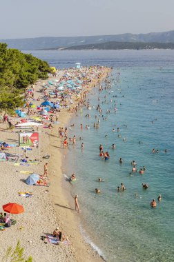 Golden Cape plajında bir sürü insan var. Altın Pelerin, Hırvatistan 'ın Brac adasındaki en ünlü plajı..