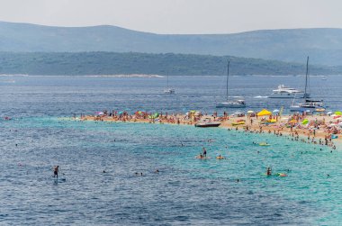 Golden Cape plajında bir sürü insan var. Altın Pelerin, Hırvatistan 'ın Brac adasındaki en ünlü plajı..