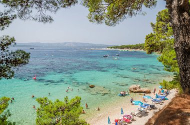 Golden Cape plajında bir sürü insan var. Altın Pelerin, Hırvatistan 'ın Brac adasındaki en ünlü plajı..