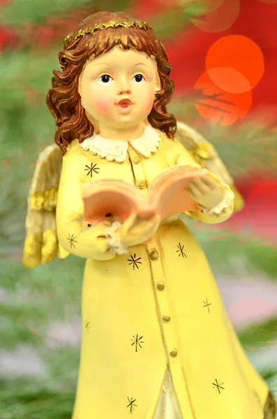 Christmas decoration, figure of little angel singing carols against bokeh background — Stock Photo, Image