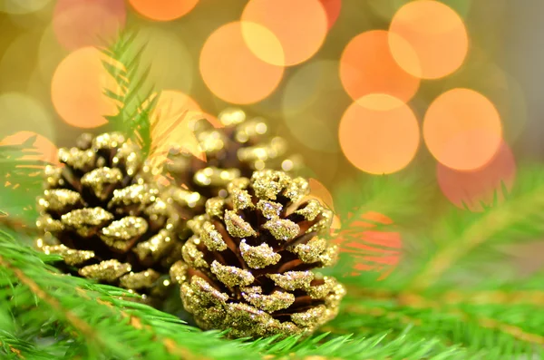 Kerstmis decoratie, gouden kegels tegen bokeh achtergrond — Stockfoto
