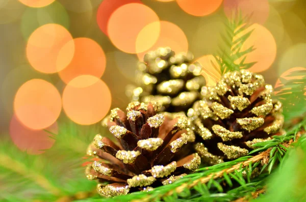 Christmas decoration, golden cones against bokeh background — Stock Photo, Image