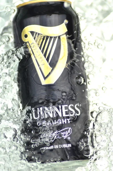 Guinness sacó cerveza en agua salpicada —  Fotos de Stock