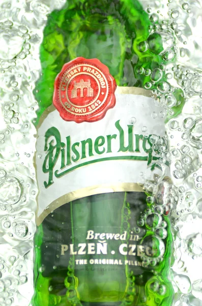 Pilsner Urquell pale lager beer in splashed water — Stock Photo, Image