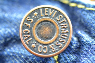 Mavi kot üzerinde Levi Strauss düğmesinin closeup.
