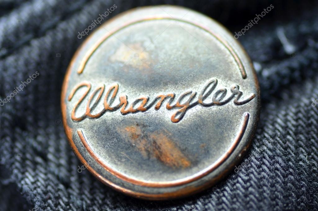 Closeup of Wrangler button on blue jeans. Wrangler is American manufacturer of jeans. Its headquarters is in Greensboro, North Carolina, USA.