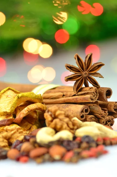 Christmas spices, nuts, cookies and dried fruits on bokeh background — Stock Photo, Image