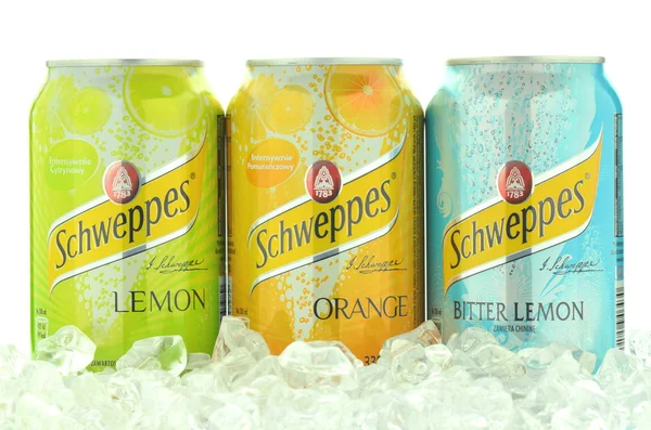 Cans of Schweppes drink on ice cubes — Stock Photo, Image