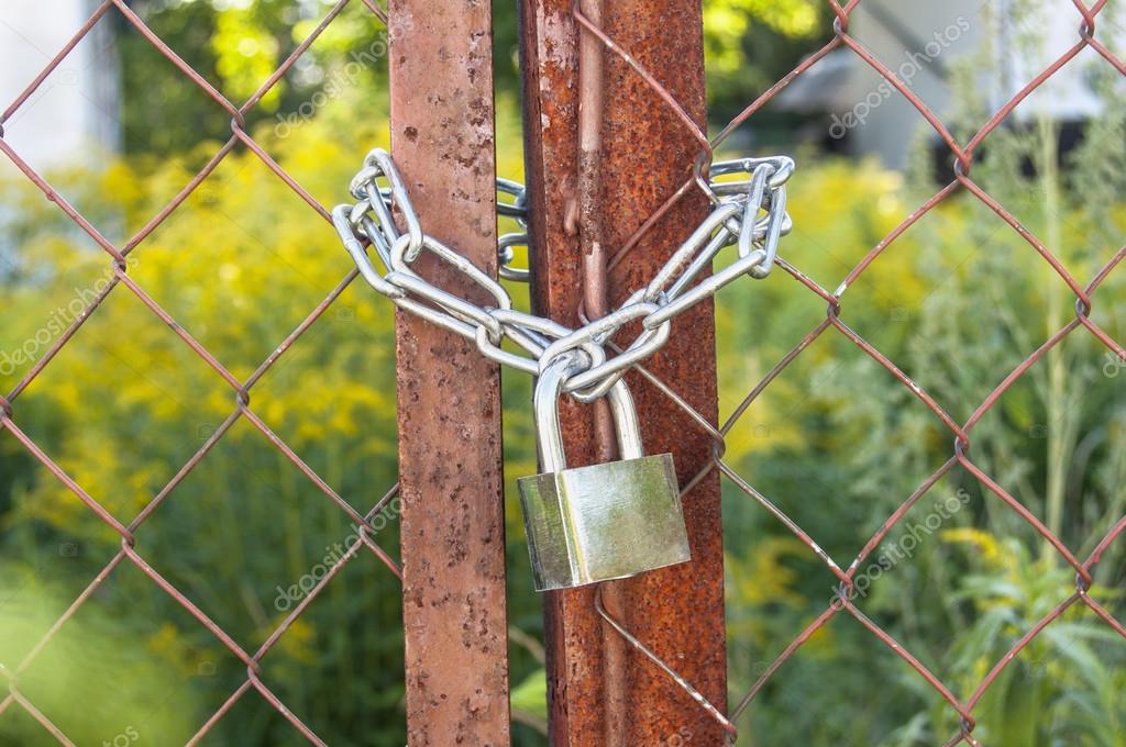 Download - A padlock on a steel chain link fence - Stock Image. 
