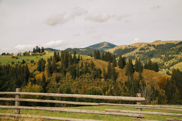 distant view of traditional houses in Carpathian mountains at autumn season, Ukraine 