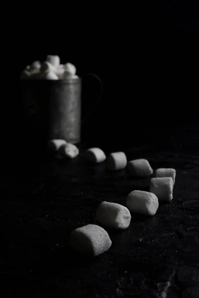 Xícara de café e marshmallows em fundo preto — Fotografia de Stock