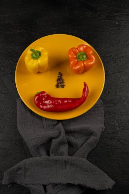 fresh and delicious, yellow, red and orange peppers on black background.