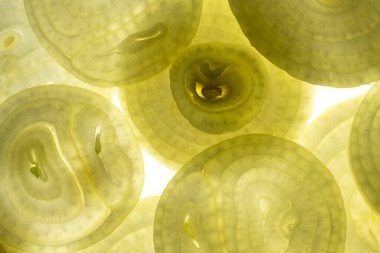 Fresh raw onion rings, slices on white background.