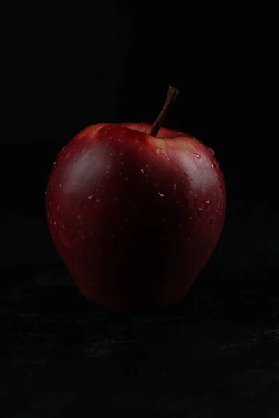 Czerwone jabłko odizolowane na czarnym drewnianym tle — Zdjęcie stockowe