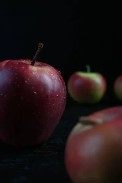 검은 나무 배경에 고립되어 있는 붉은 사과 — 스톡 사진