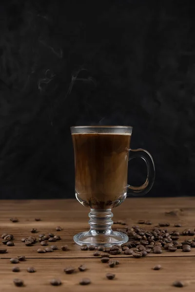 Vapor café sobre superfície de madeira e fundo preto — Fotografia de Stock