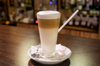 Barda, ahşap masada, cam bardakta kahve.