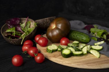 Köy karatahtasında salata yapmak için gerekli malzemeler. Kasede sebze salatası, domates, salatalık, domates kumato. Sağlıklı, temiz yeme konsepti. Vegan ya da glütensiz diyet.