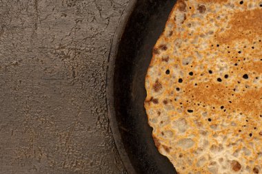 Tahta masadaki tavada ev yapımı lezzetli kırsal krep. Masa üstü görünümü. Maslenitsa yemeği.