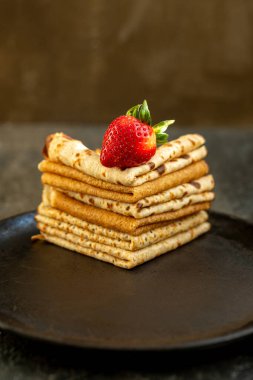 Tahta masadaki tavada böğürtlenli ev yapımı kırsal krep. Maslenitsa yemeği.
