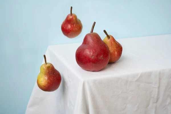 Röda Päron Blå Bakgrund Och Vitt Bord — Stockfoto