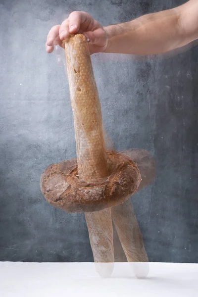 Menyeimbangkan Roti Atas Meja Dengan Latar Belakang Abu Abu — Stok Foto