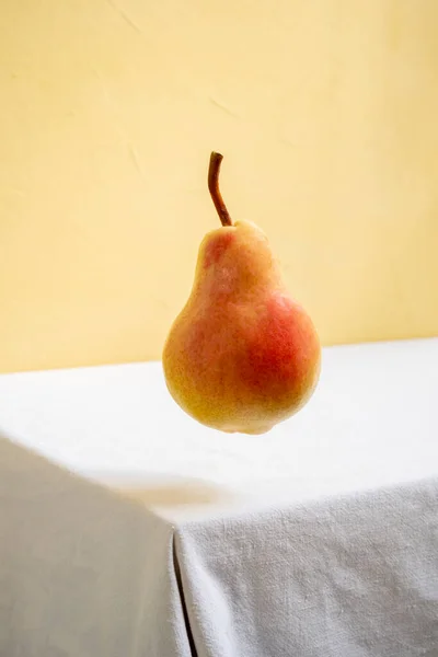 Birne Schwebt Der Luft Auf Weißem Tisch Und Gelbem Hintergrund — Stockfoto