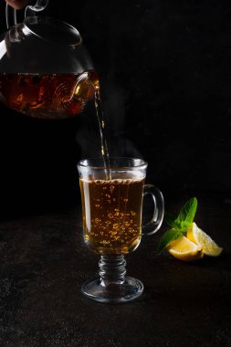 Şeffaf bir çaydanlıktan siyah bir fincana siyah çay dök.