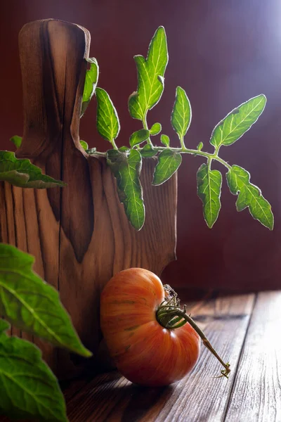 新鮮な熟したカラフルな野菜トマトと古い木製のテーブルの上の木製のボードのヒープ 暗い素朴な雰囲気 鍵が低い — ストック写真