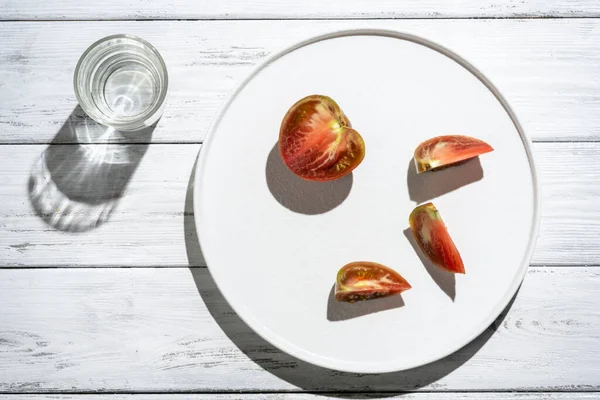 Tomat Piring Putih Dengan Bayangan Pada Latar Belakang Kayu Putih — Stok Foto